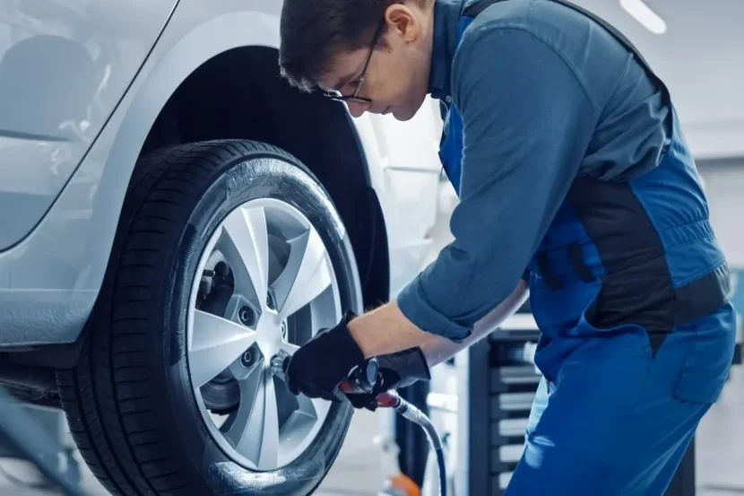 mechanik odkręcający koło w samochodzie