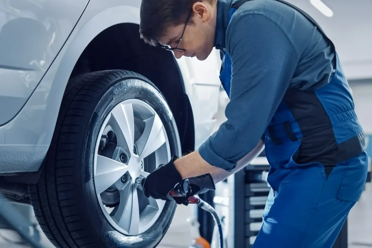 mechanik odkręcający koło w samochodzie